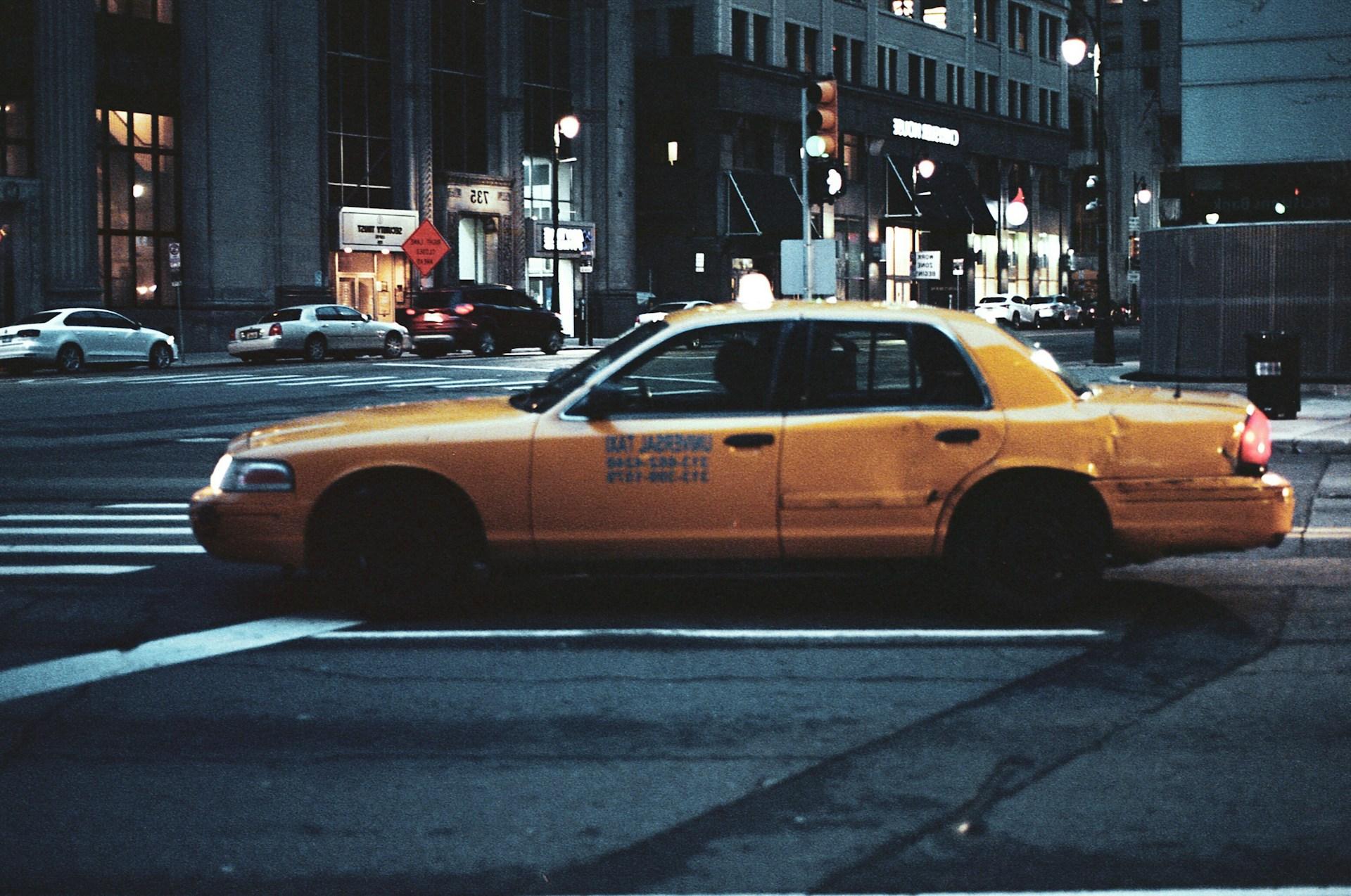 a yellow taxi in a city a yellow taxi in a city