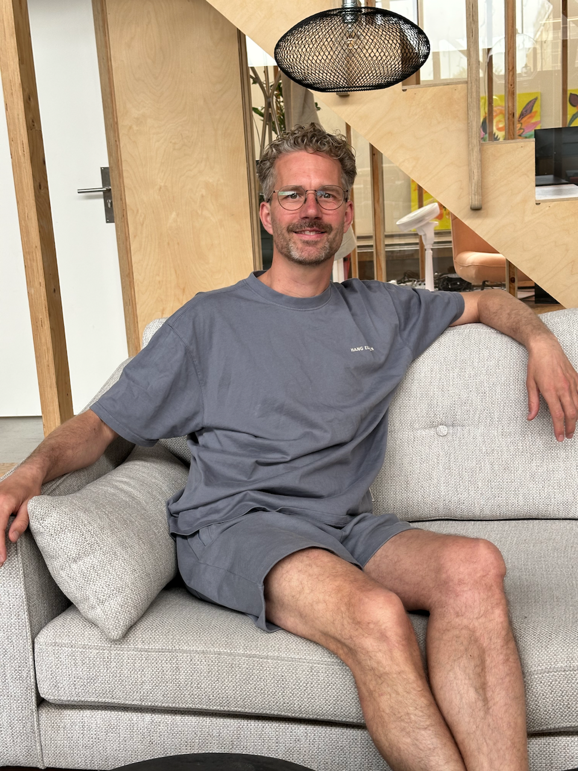 Niels de Feyter seated on a sofa in an office workspace.
