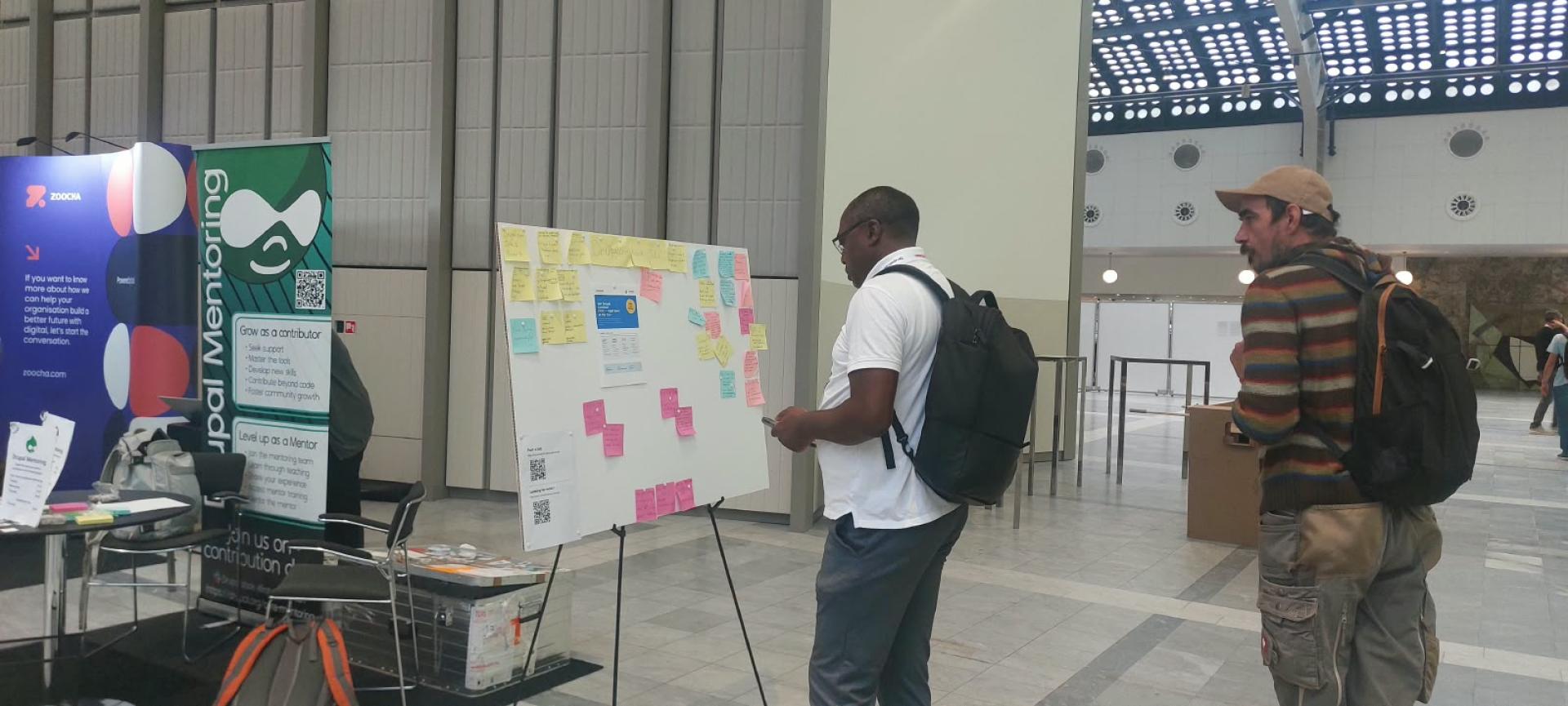 Attendees viewing the jobs board on the DrupalCon Rotterdam exhibition floor.