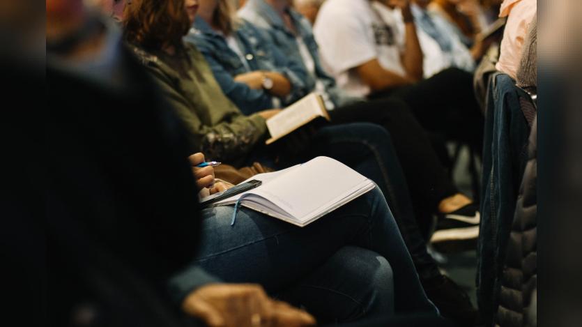 A photo from Victory Church, Jeffreys Bay, South Africa, where devotees are attending a sermon with notebooks and bibles in their hands.