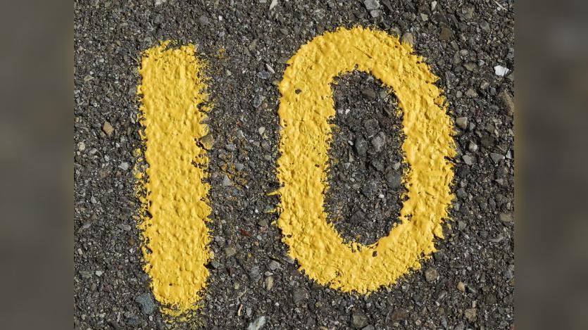 Number 10 drawn with yellow paint on gravel road 