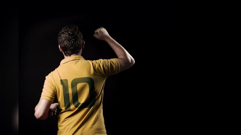 a person wearing Yellow coloured No. 10 jersey photographed from back