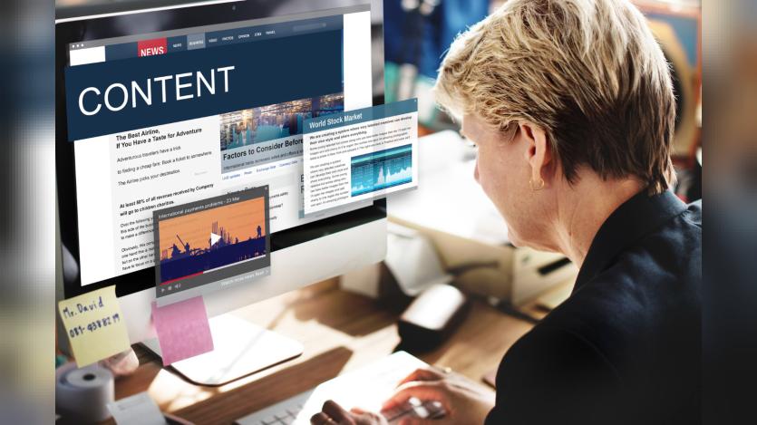 A woman looking into a desktop screen of news contents