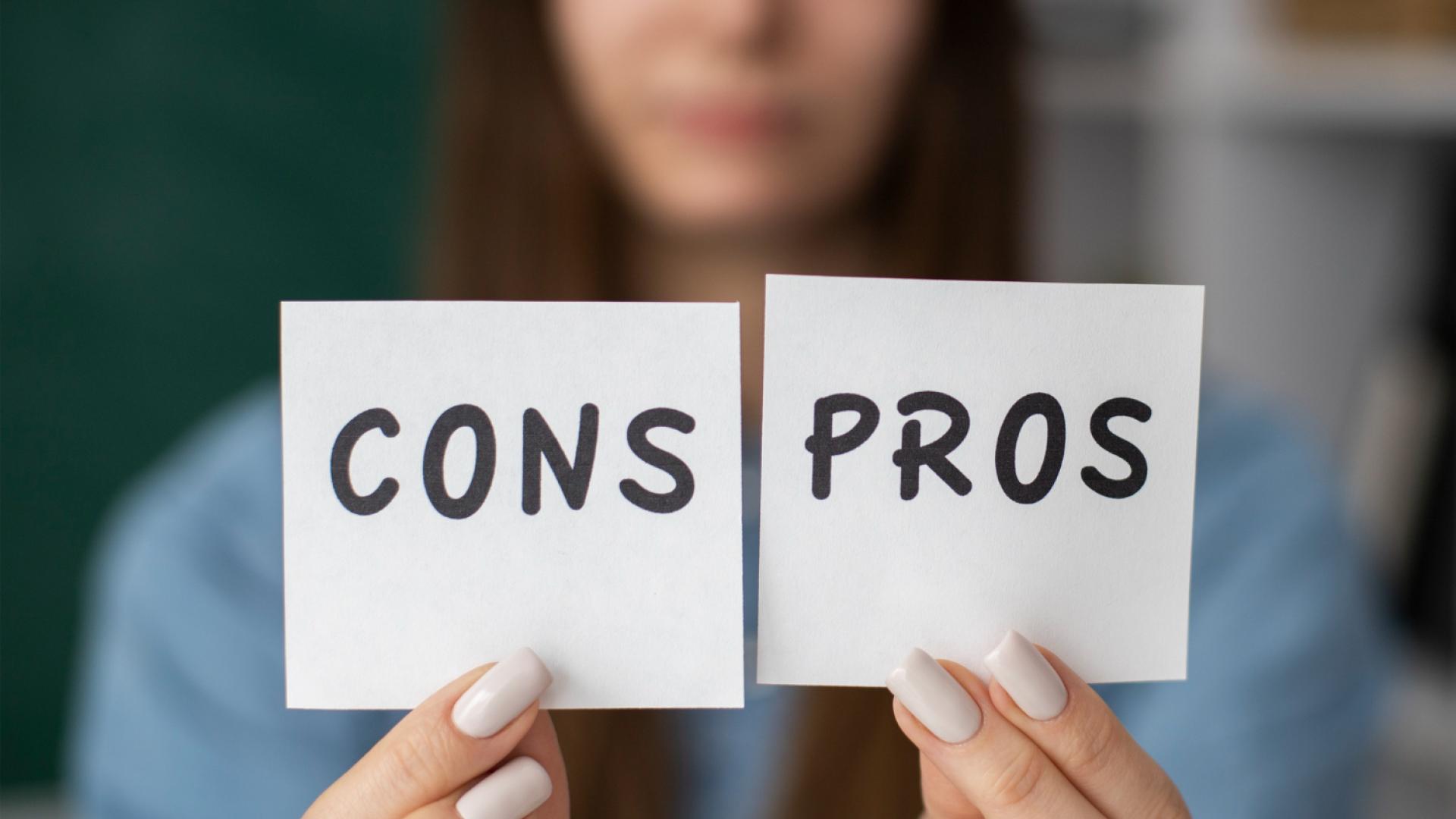 Blurry woman holds pros and cons post-its