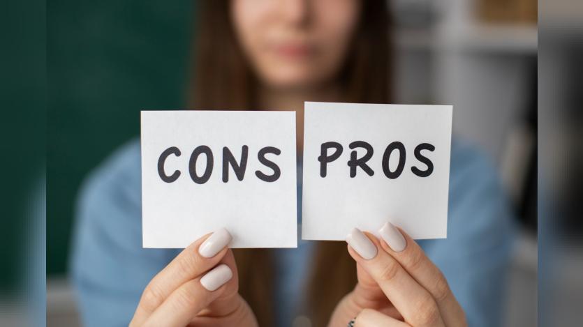 Blurry woman holds pros and cons post-its