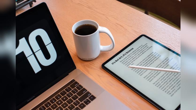 A laptop, a tablet and a coffee cup on the table