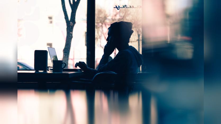 a person looking at laptop in a cafe