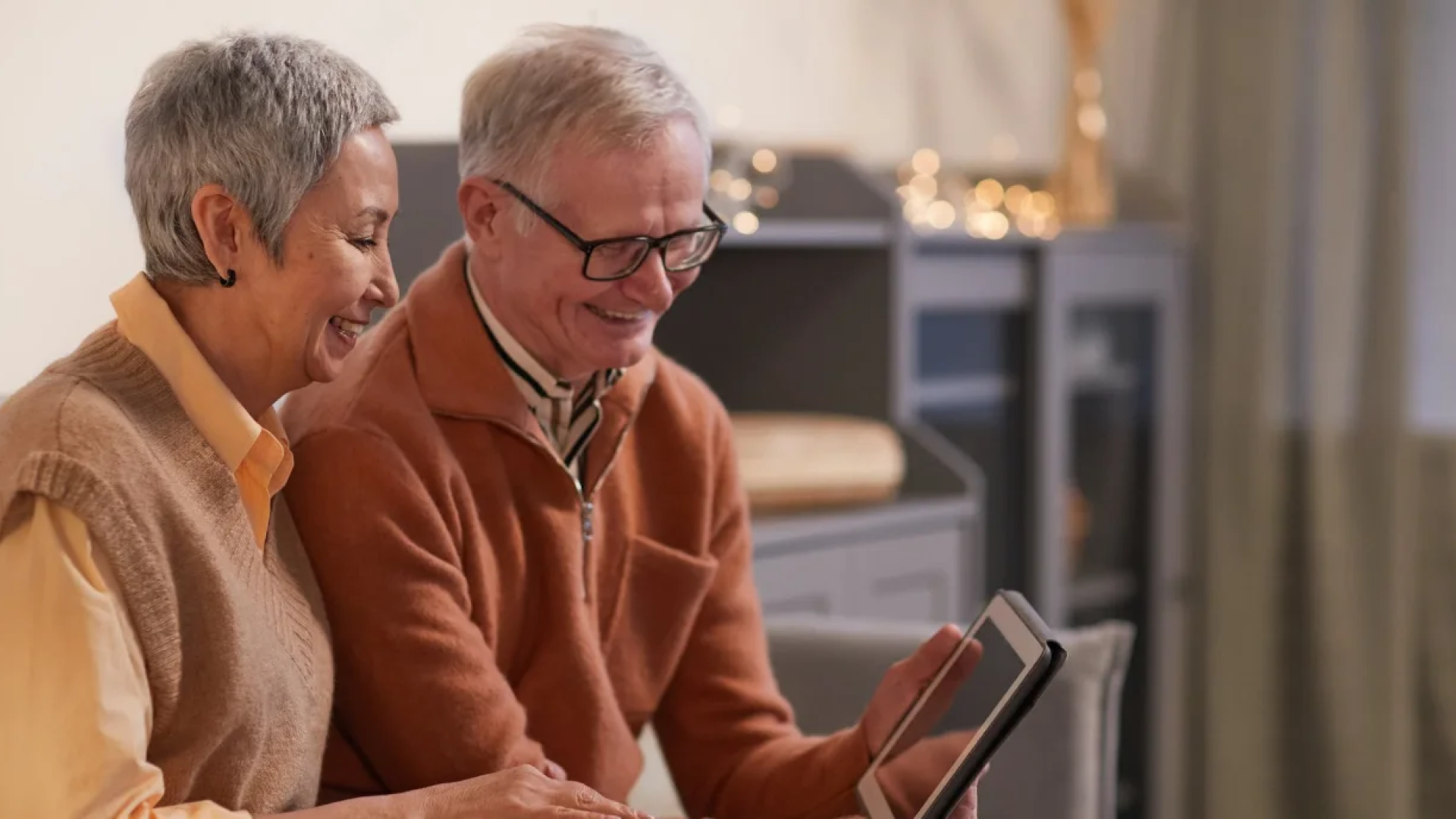 an old couple looking at an ipad