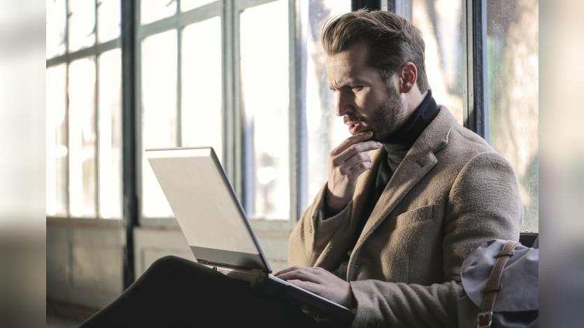 Man confusedly staring at his laptop screen
