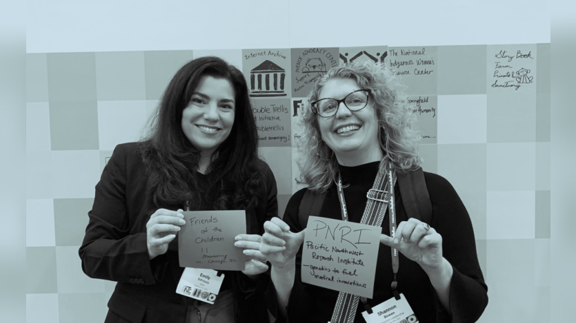 two women standing holding placard
