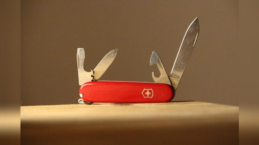 A swiss army knife on a wooden table. Photo:  Denise Jans