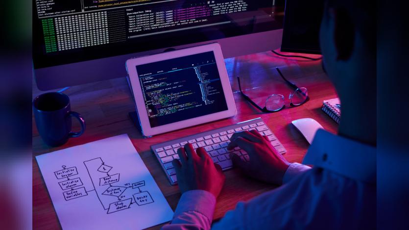 Professional programmer working late in the dark office
