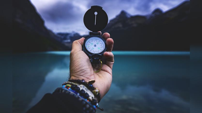 a hand holding a compass
