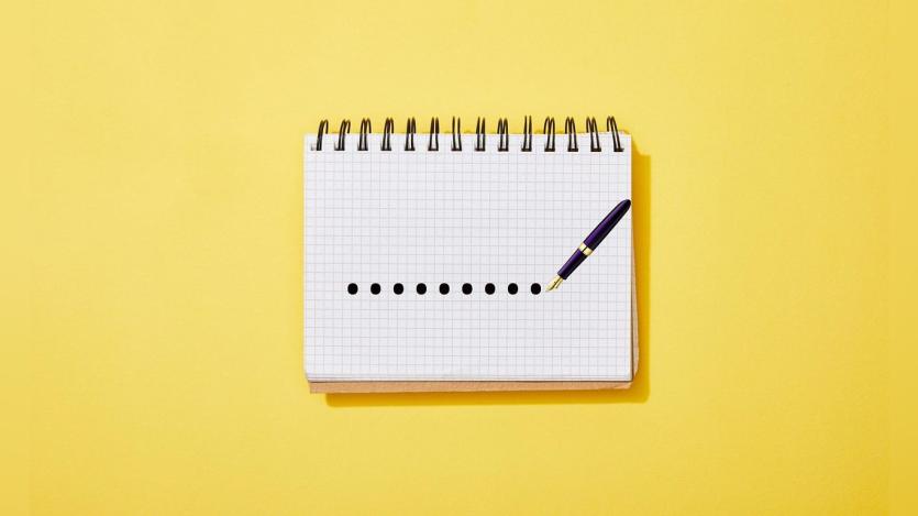 a pen marking dots on a notepad