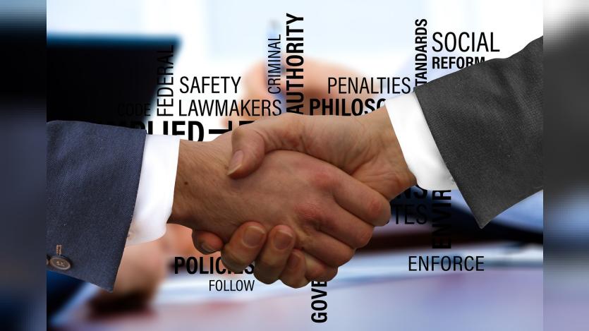 two hands of professionals shaking hands and different values in connection with governance