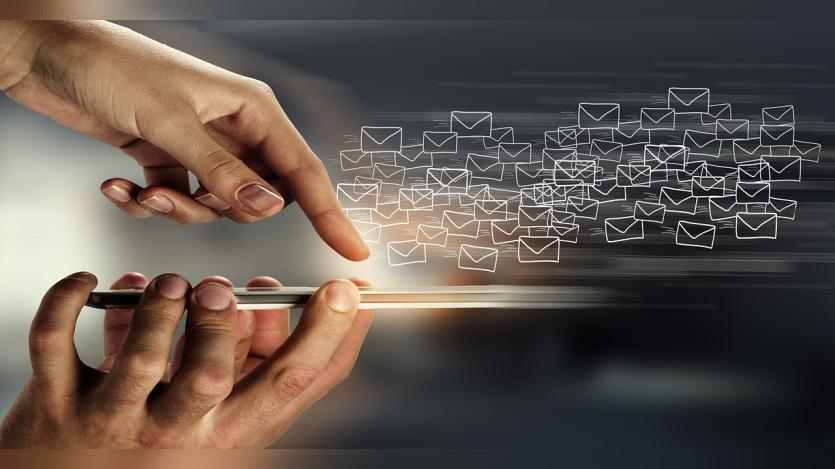 A finger touching a phone and lots of envelopes  flying away