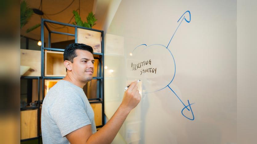 Man writing Marketing Strategy on White board