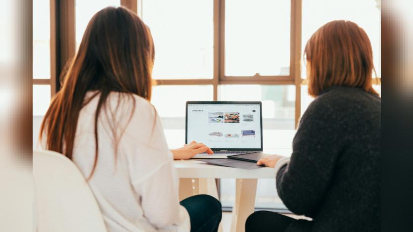 two ladies looking at a laptop screen