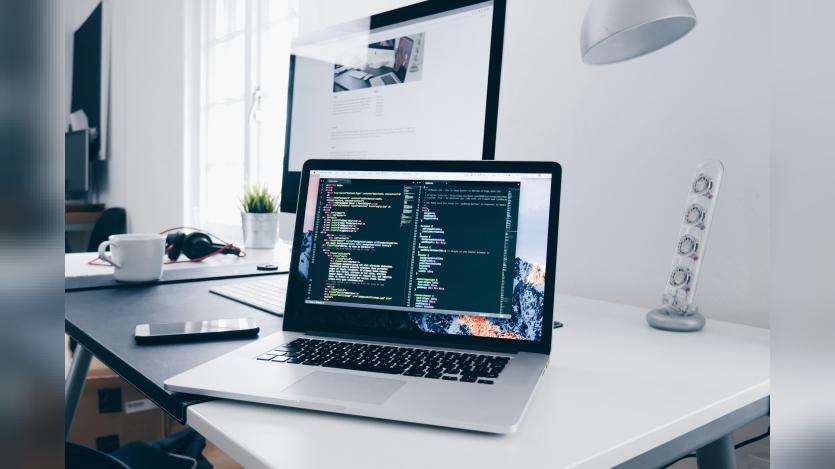 A macbook with lines of code in a termial window