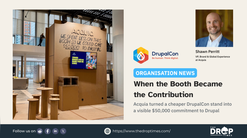 Acquia's cardboard exhibition booth at DrupalCon Rotterdam with a handwritten message stating that the company spent less on the booth so it could give $50,000 to Drupal.