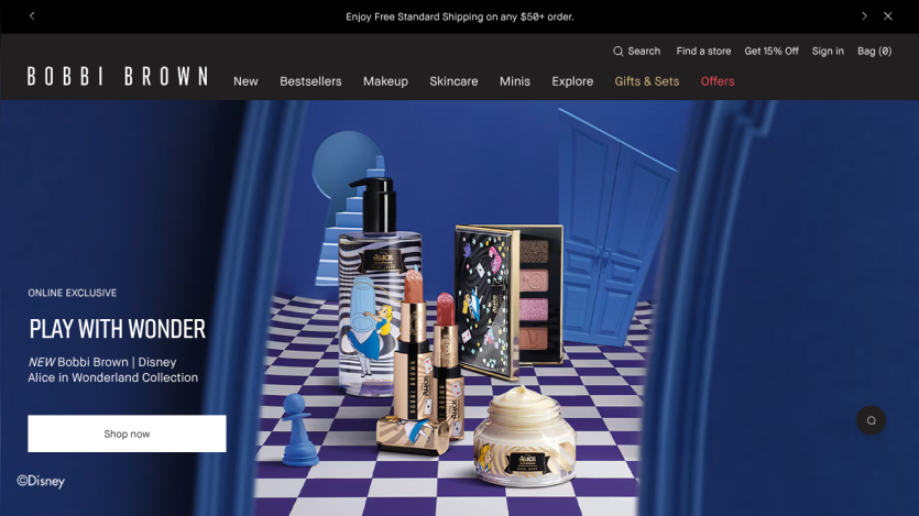 Bobbi Brown Disney Alice in Wonderland makeup collection with lipstick, cream, and palette on a blue checkered floor