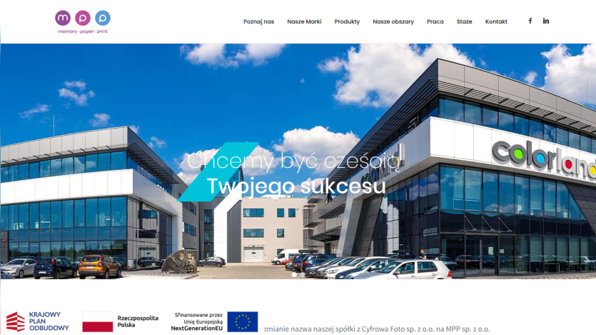 Corporate website with navigation menu and hero image of modern office buildings under a blue sky
