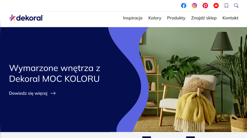 Dekoral homepage with navigation and a hero section promoting colorful interior design featuring a cozy chair and plants