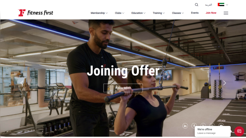 Fitness First gym website showing a joining offer with a trainer assisting a woman in exercise