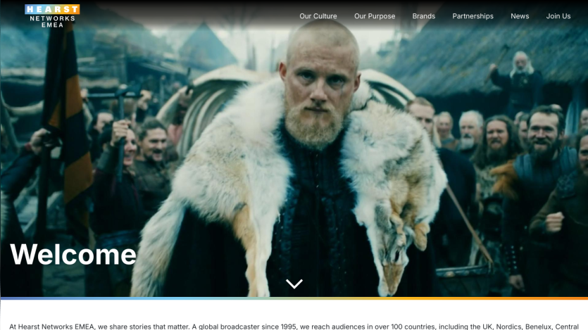 Welcome message with a prominent figure in a fur coat and a crowd in the background.