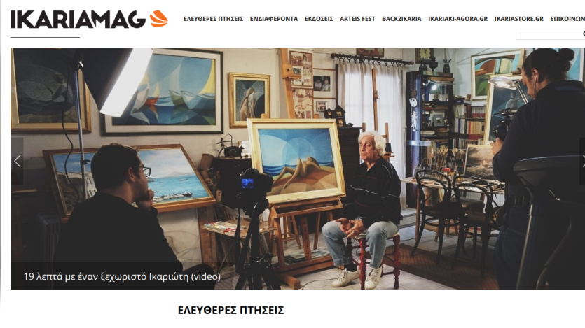 An artist being interviewed in a studio surrounded by paintings.