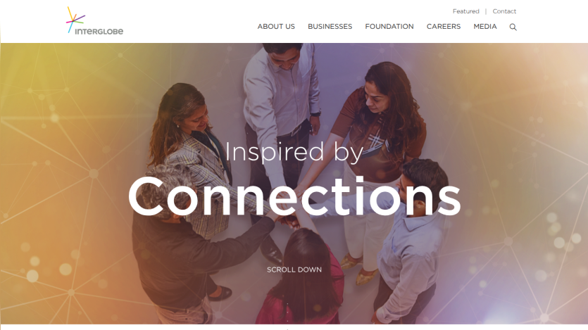 Corporate website homepage with navigation and hero section featuring diverse team joining hands and text Inspired by Connections