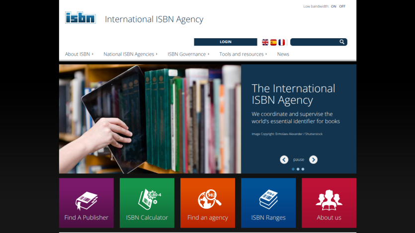 International ISBN Agency homepage with navigation, hero image of hand holding tablet near books, and key text about coordinating book identifiers