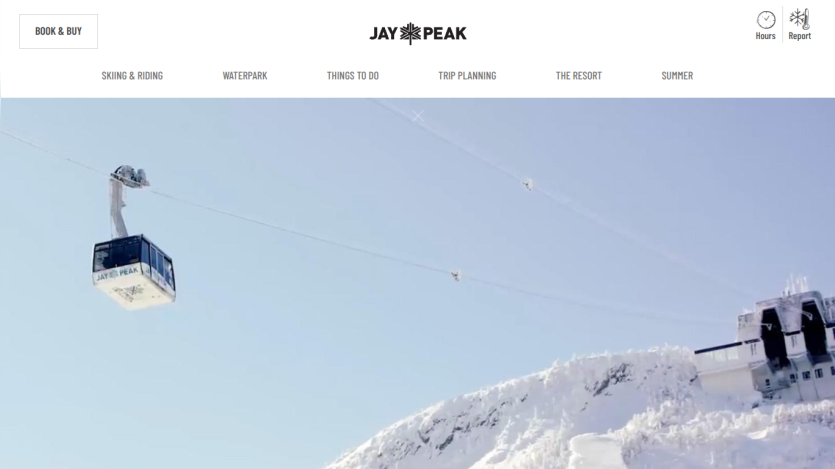 Jay Peak ski resort homepage with navigation and a skier in deep snow