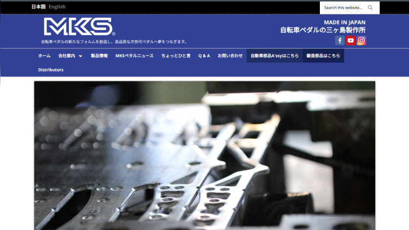 MKS Japan website header with navigation and a close-up image of metal parts manufacturing