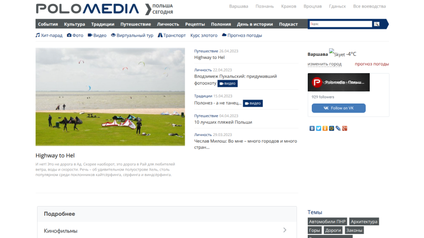 Website header with logo, navigation, and a beach scene with people and kites.