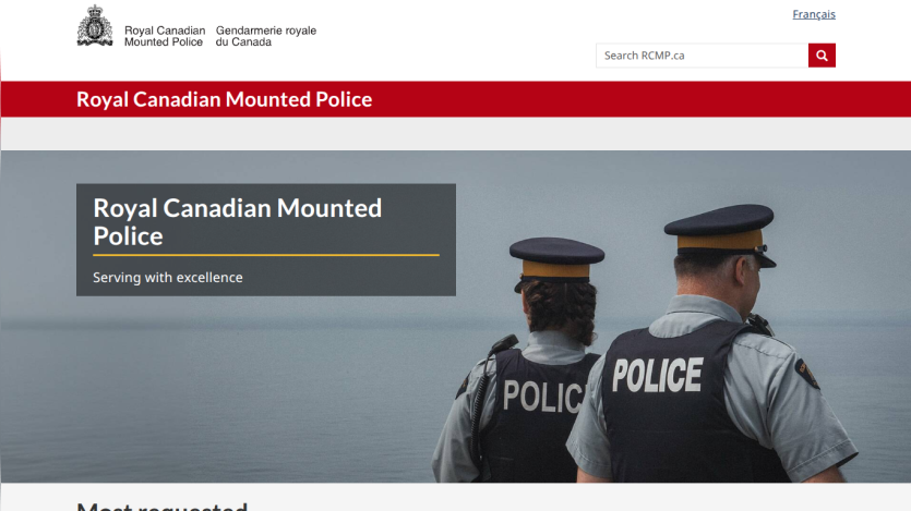 Royal Canadian Mounted Police website header with search bar and hero section showing two police officers by water and slogan 'Serving with excellence'