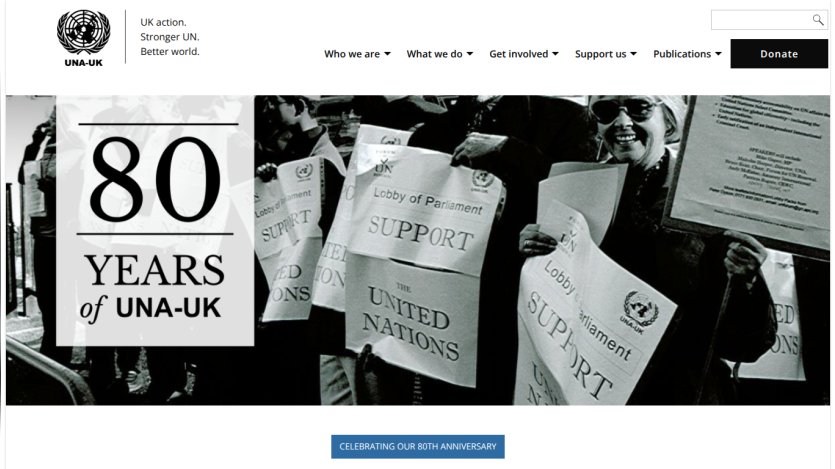 UNA-UK website celebrating 80 years with a black and white photo of people holding United Nations support signs and navigation menu.