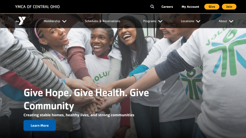 YMCA of Central Ohio homepage with navigation and a volunteer group photo with text about giving hope, health, and community