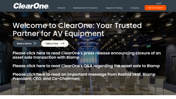ClearOne homepage with navigation, welcome message, demo and tour buttons, and press release announcements over conference room background.