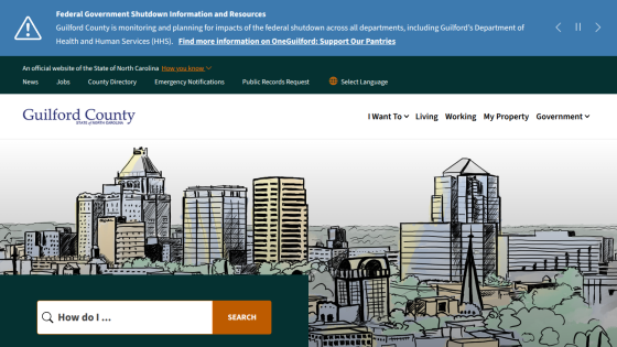 Guilford County government website homepage with city skyline illustration and search bar