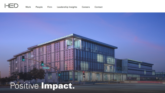 Website header with navigation and hero image of a modern building at dusk with text 'Positive Impact.'
