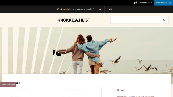Knokke-Heist tourism website with header, search bar, and hero image of two people by the sea with seagulls