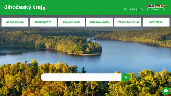 Jihočeský kraj website with green header, navigation menu, and scenic lake and forest background