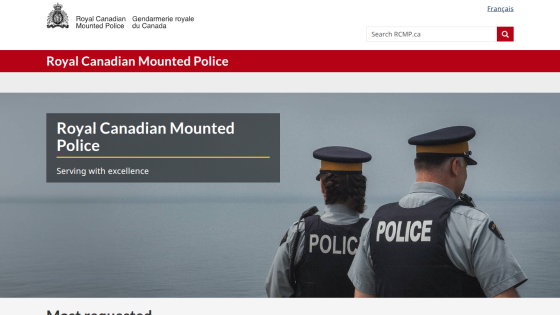 Royal Canadian Mounted Police website header with search bar and hero section showing two police officers by water and slogan 'Serving with excellence'