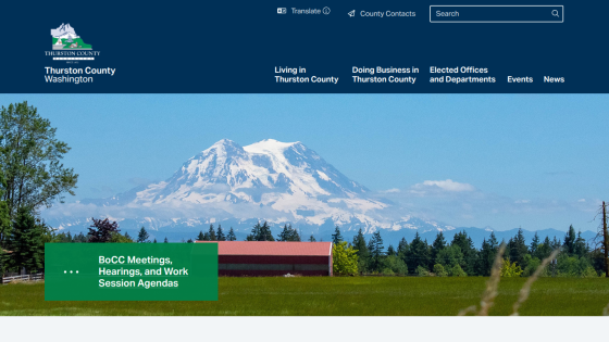 Thurston County Washington official site with navigation links and a scenic mountain landscape background