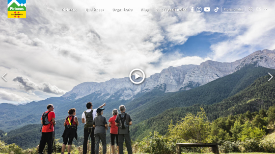 Group of hikers overlooking a mountainous landscape with a play button for a video.