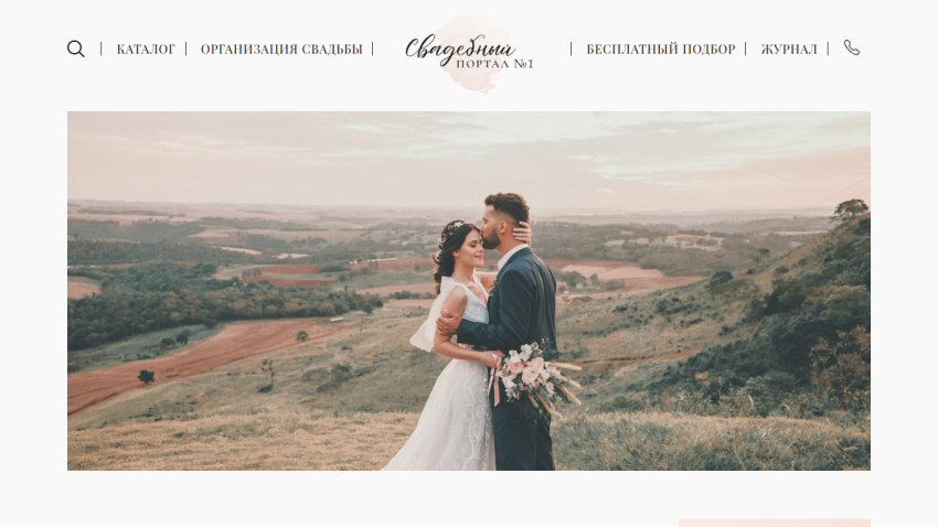 A couple in wedding attire embracing in a scenic landscape with hills.