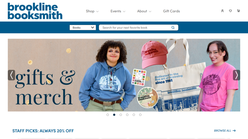 Brookline Booksmith website header with navigation, search bar, and hero section featuring gifts and merchandise with two people modeling apparel
