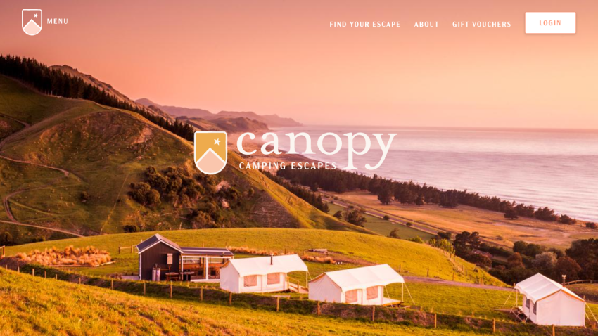 Camping escapes website with scenic coastal hillside and tents under a sunset sky, navigation links and login button