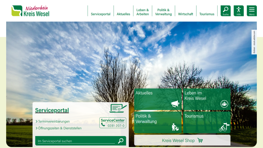 Niederrhein Kreis Wesel website with service portal, news, politics, tourism links, and contact info over a scenic sky background